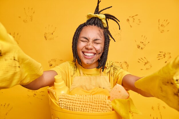 무료 사진 dreadlocks를 가진 기쁜 젊은 아프리카 계 미국인 여성은 행복하게 웃는다.