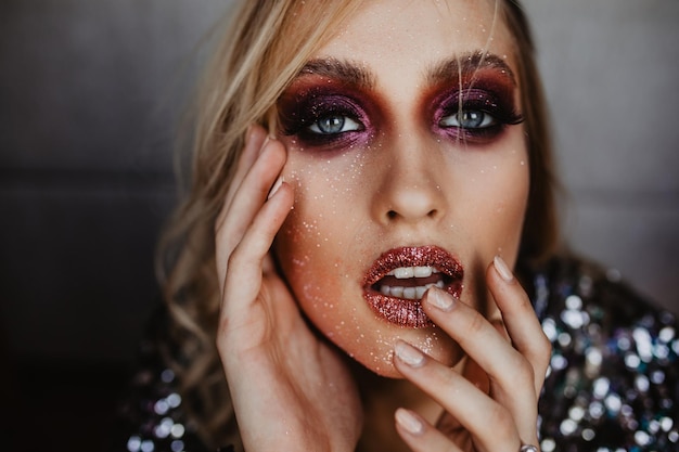 Free photo glad young model with party makeup looking to camera indoor shot of refined blonde woman