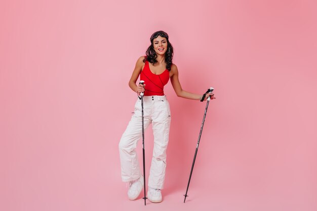 Glad young woman holding ski poles