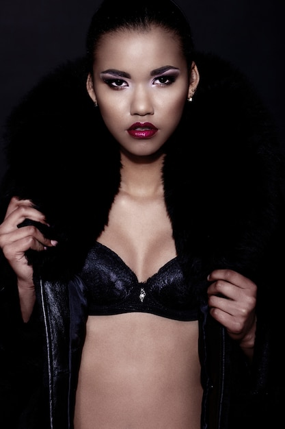 glamor closeup portrait of beautiful sexy black young woman model with bright makeup  with perfect clean with red lips in fur coat