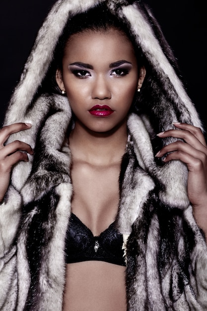 glamor closeup portrait of beautiful sexy black young woman model with bright makeup  with perfect clean with red lips in fur coat