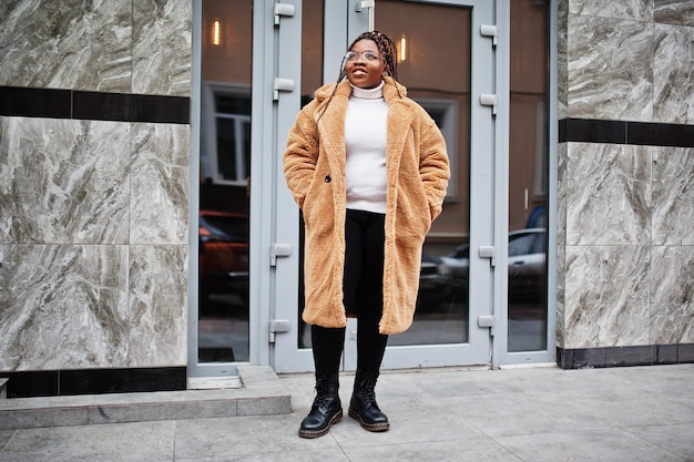 Glamorous african american woman in warm fur coat eyeglasses pose at street