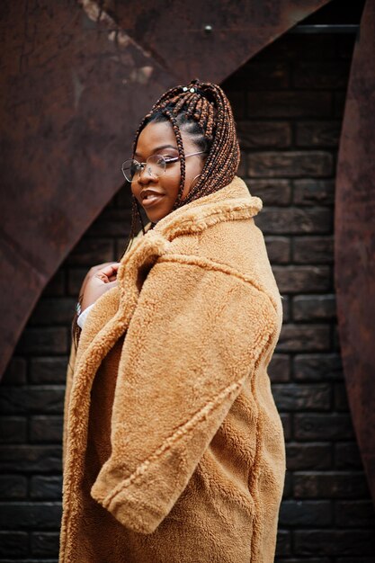 Glamorous african american woman in warm fur coat eyeglasses pose at street