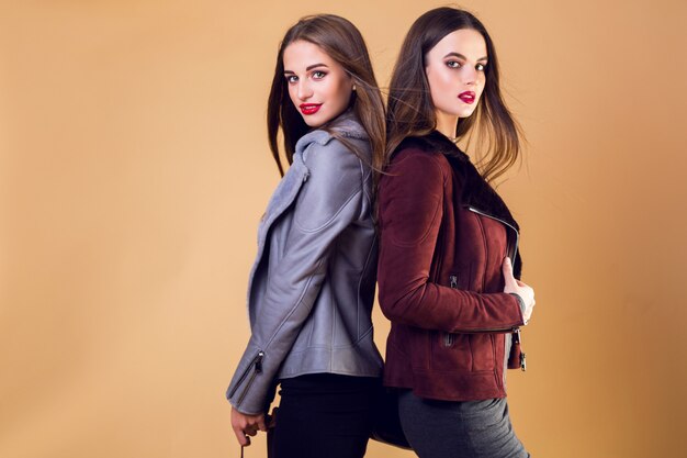 Glamorous pretty women posing and wearing casual winter jackets