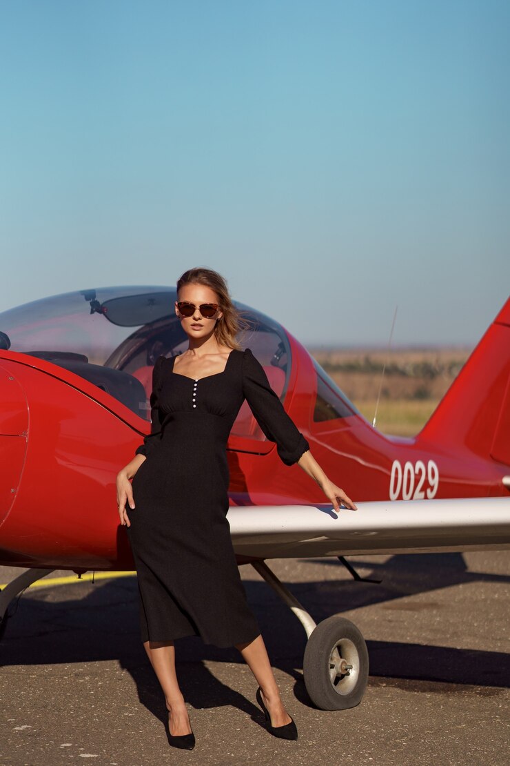 無料Photo 飛行機でポーズをとる華やかな女性