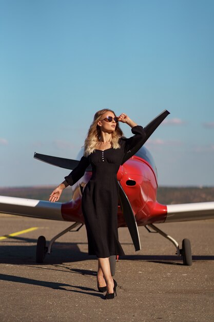 飛行機でポーズをとる華やかな女性