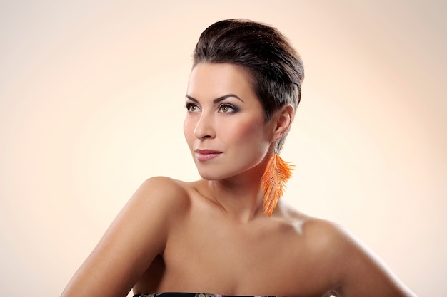 Glamour and gorgeous brunette with feather earring