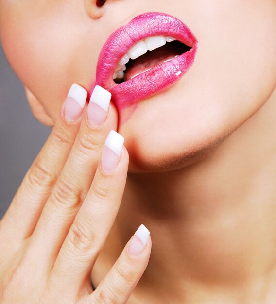 Glamour pink gloss lips with temptation gesture.