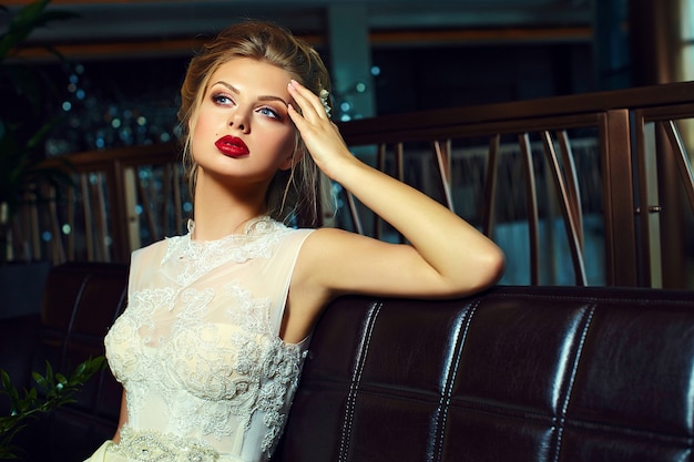 glamour stylish blond bride with bright makeup and with red lips