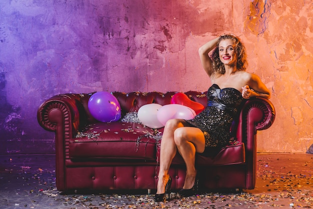 Glamour woman adjusting hair on couch