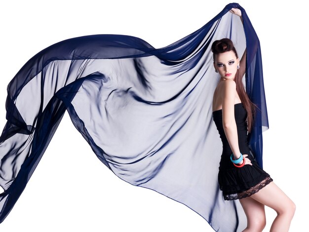 Glamour young model with motion chiffon - white wall