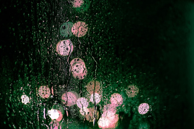 빗방울에 창을 통해 밤 도시의 눈부심