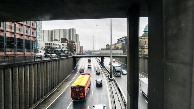 Glasgow cityscape United Kingdom Highway with multiple cars old and modern buildings cloudy weather