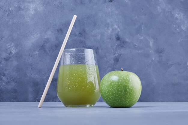 A glass of apple juice with pipe.