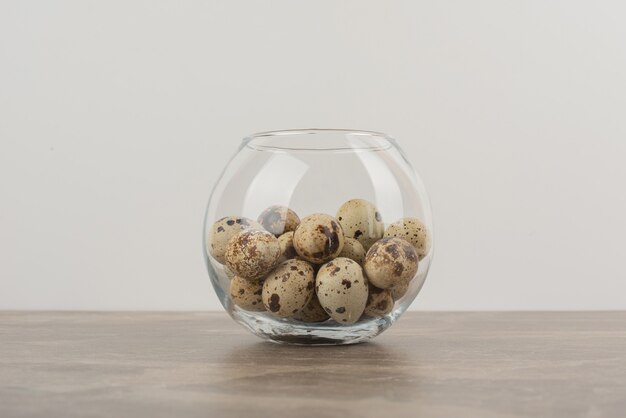 Glass ball of quail egg on marble table .