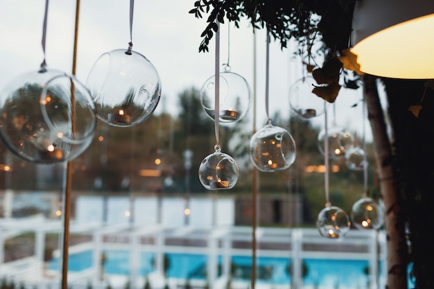 Glass balls with candles hang before the window