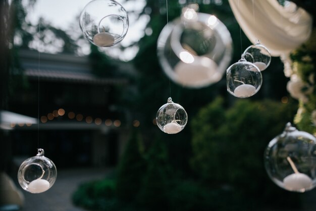 Glass balls with candles hang from wedding altar