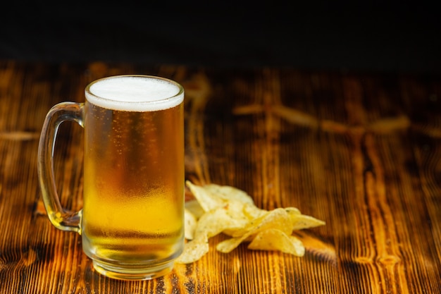 グラス1杯のビールが木の床に置かれます。