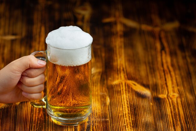 A glass of beer is placed on the wooden floor.