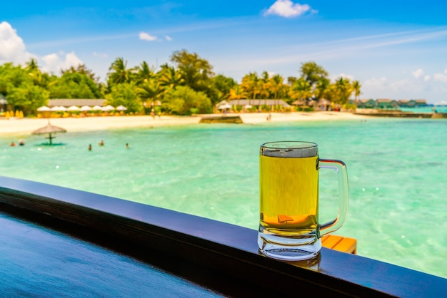 Foto gratuita un bicchiere di birra con bella isola tropicale delle maldive.