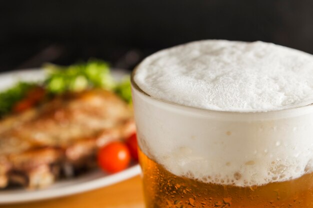 Glass of beer with defocused steak