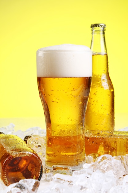 黄色の背景に泡とビールのグラス