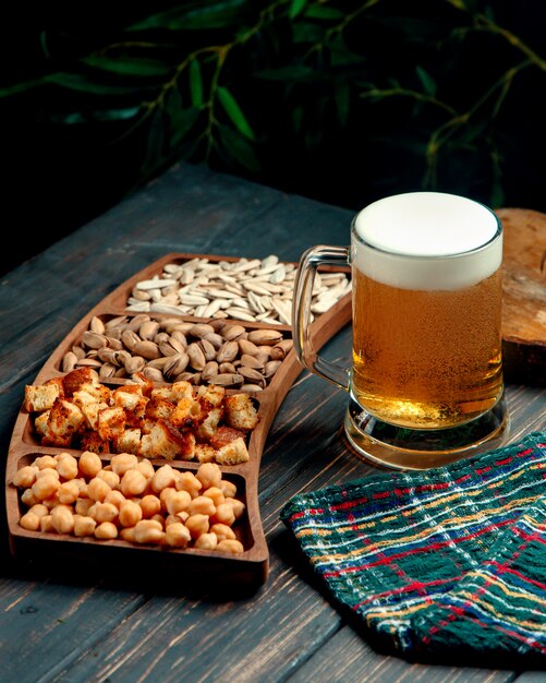 Glass of beer with froth and snacks