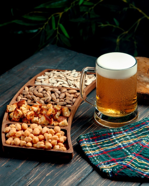 Glass of beer with froth and snacks