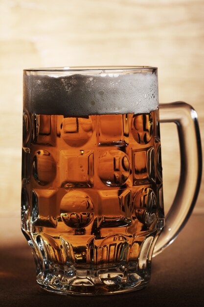 Glass of beer over wooden surface