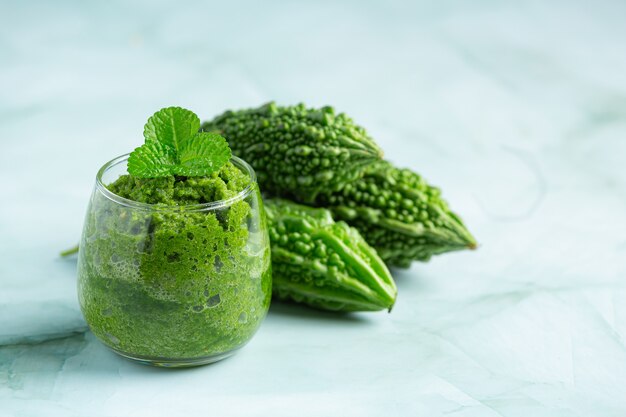 a glass of bitter gourd smoothie with shopped bitter gourd