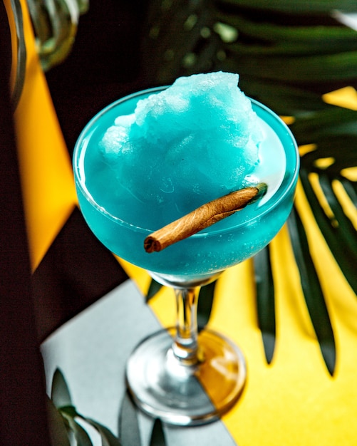 glass of blue lagoon with ice shaving and cinnamon stick