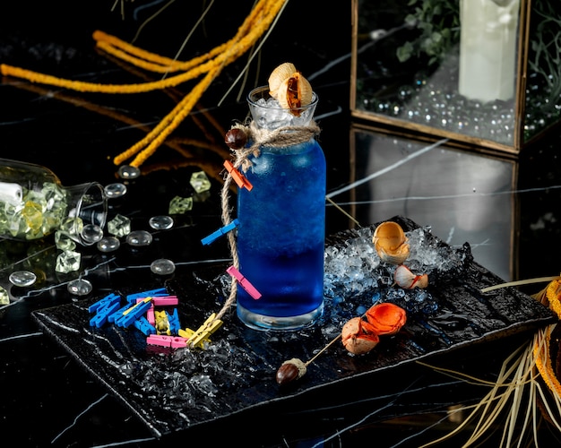 glass bottle of blue lagoon decorated with rope and colourful clothespin