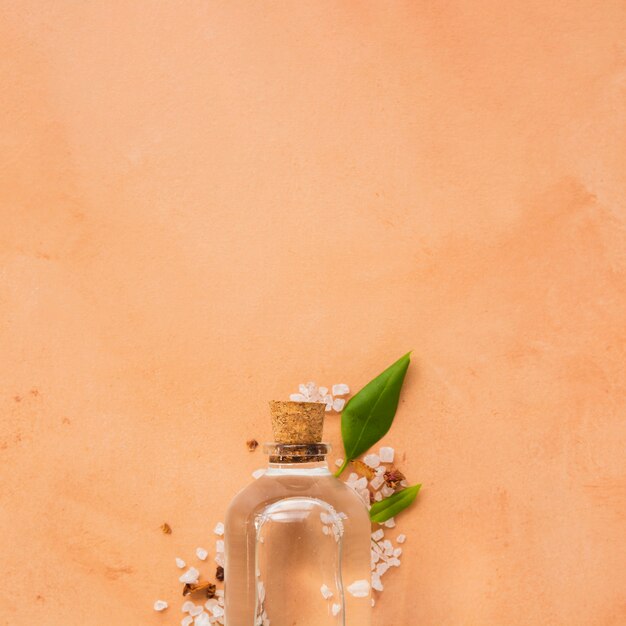 Glass bottle on orange background with copy space