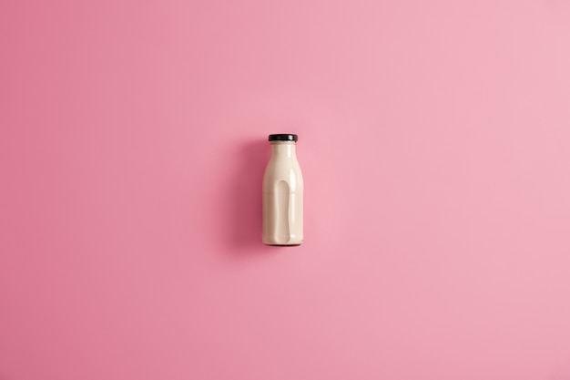 Glass bottle of plant based lactose free vegetarian white milk for your healthy nutrition. Homemade organic nutrient beverage made of coconut, soybean, oat or cashew. Fresh alternative drink