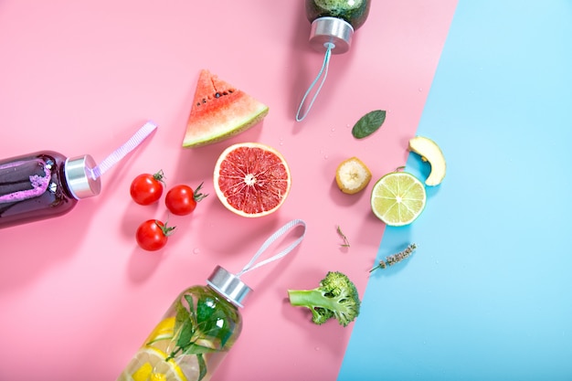 Glass bottles with natural drinks on a colored wall