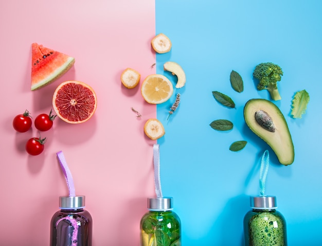 Бесплатное фото Стеклянные бутылки с натуральными напитками на цветном фоне
