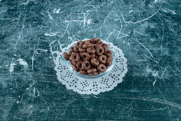 Free photo a glass bowl of corn rings on caster on the blue surface