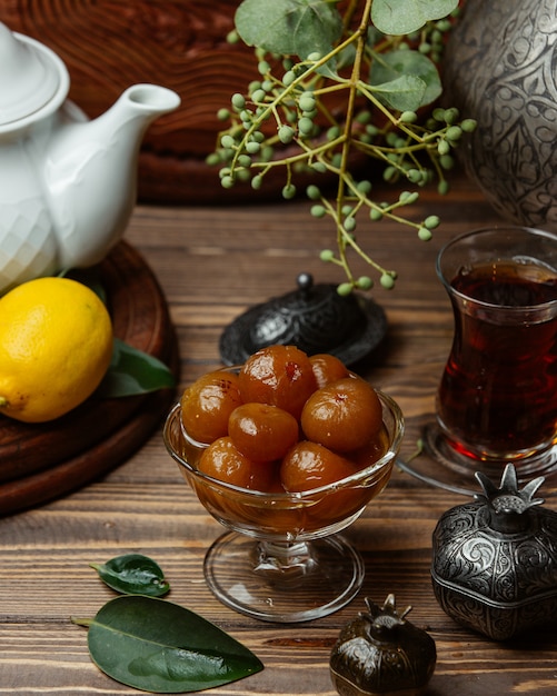 a glass bowl of injir jam served with a pot of tea