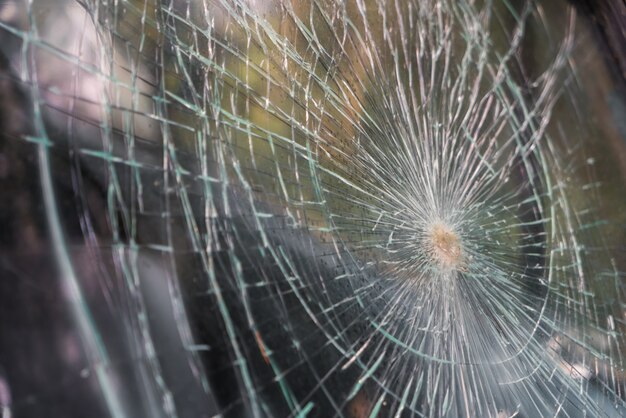 Glass broken cracks splinters in front of car . ( Filtered image