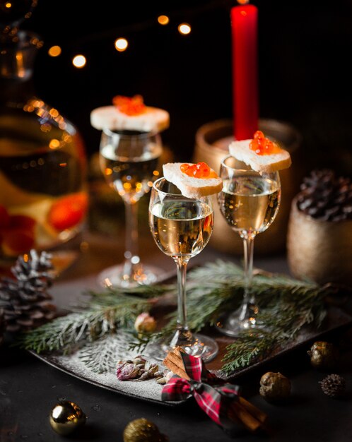 glass of champagne and gray bread with red caviar