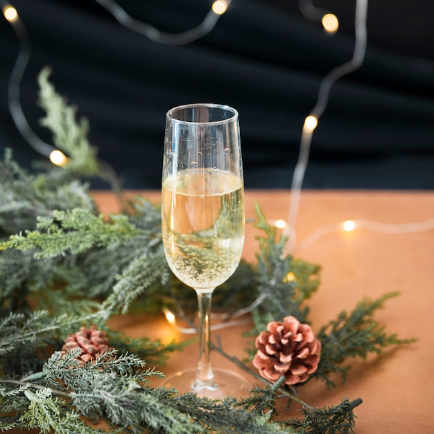 Free photo glass of champagne with green branches