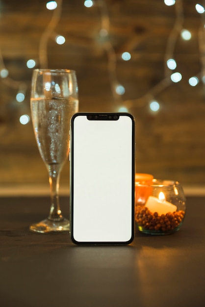 Free photo glass of champagne with phone on table