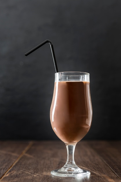 Glass of chocolate milkshake with straw and copy space
