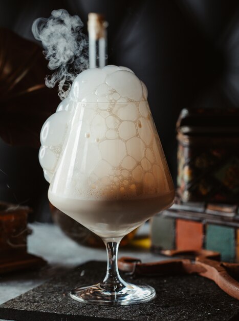 A glass of cocktail with cream bubbles