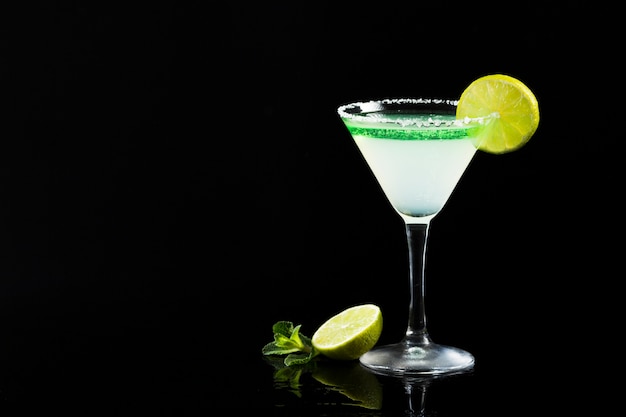 A glass of cocktail with lime and copy space