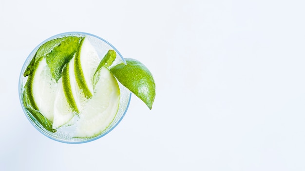 Glass of cocktail with slices of lime and peppermint