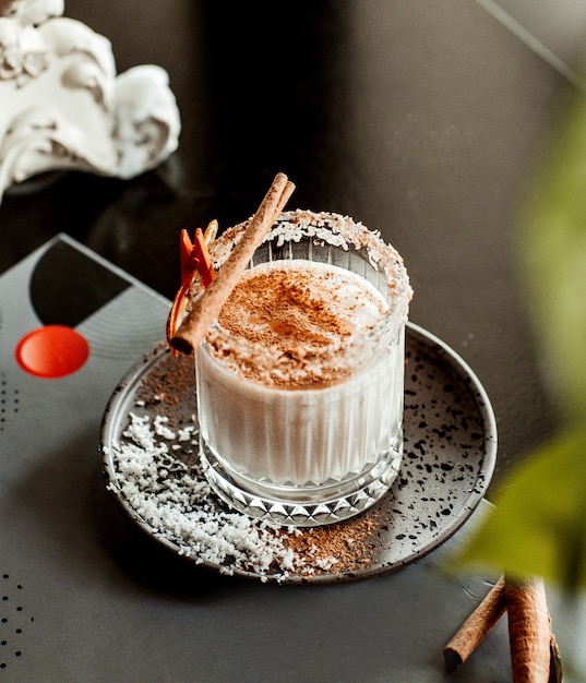 glass of coconut cocktail garnished with ginger sprinkles