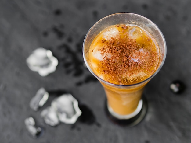 Glass of coffee cocktail with ice cubes and powder