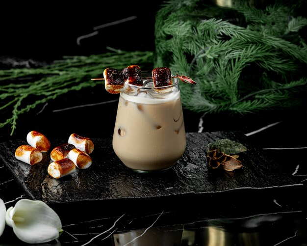 Free photo glass of coffee drink with ice garnished with toasted marshmallow