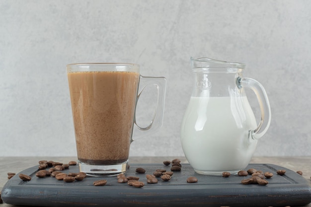 Foto gratuita bicchiere di caffè e latte sulla lastra scura